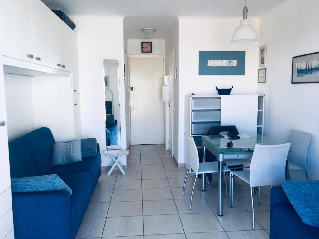 a living room with a blue couch and a table at Gabriella in Menton