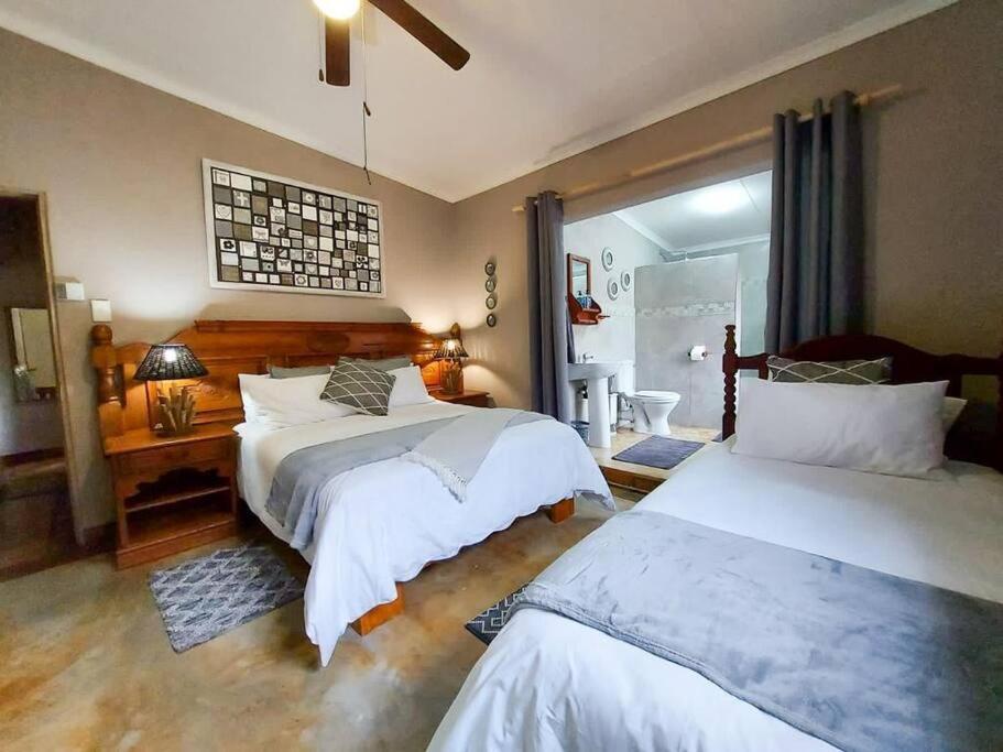 duża sypialnia z 2 łóżkami i oknem w obiekcie InnibosRus Self-catering w mieście White River