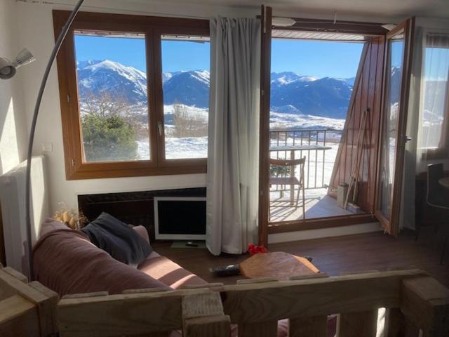 a living room with a couch and a view of mountains at Studio face aux montagnes Font-Romeu in Font-Romeu-Odeillo-Via