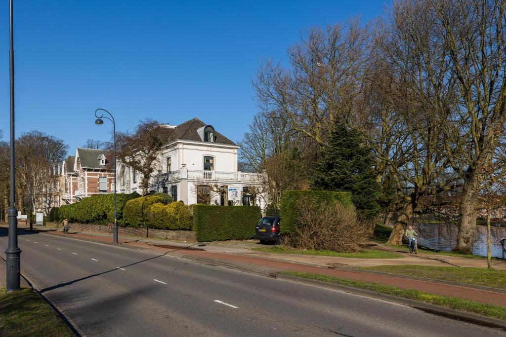 哈萊姆的住宿－Oase van Haarlem, 15 minuten van Amsterdam，街道边的白色房子,有停车位