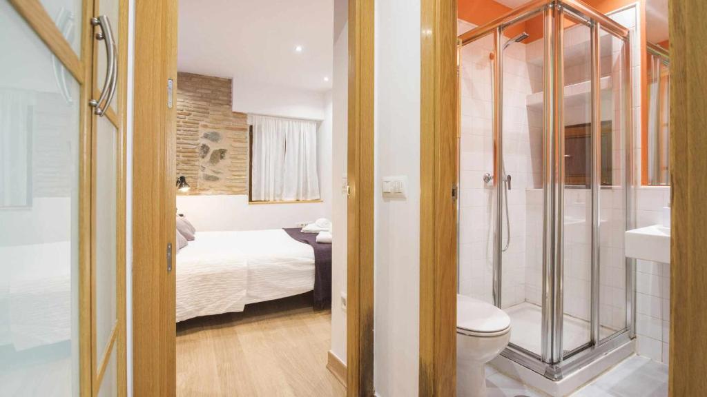 y baño con cama, ducha y aseo. en La Casita de Toledo by Toledo AP, en Toledo
