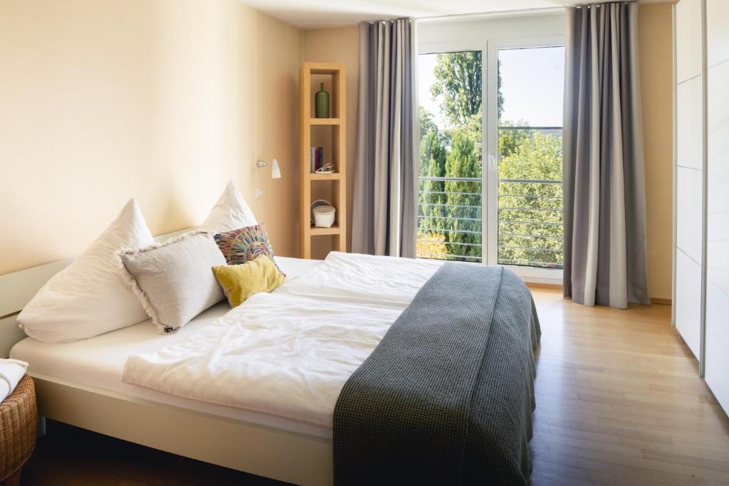 een slaapkamer met een bed en een groot raam bij Kurviertel Wohnung I in Überlingen