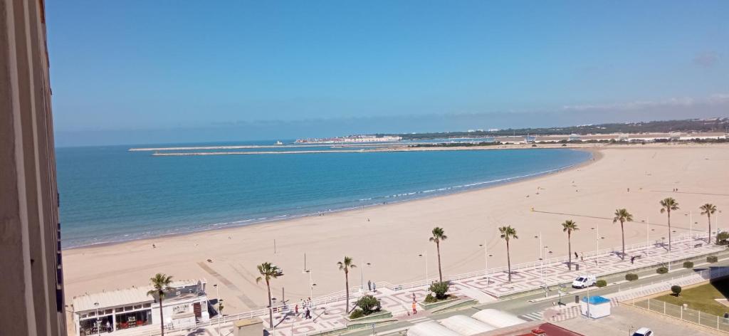 vistas a una playa con palmeras y al océano en Valdelagrana vista al mar Puerto de Santa María, en El Puerto de Santa María