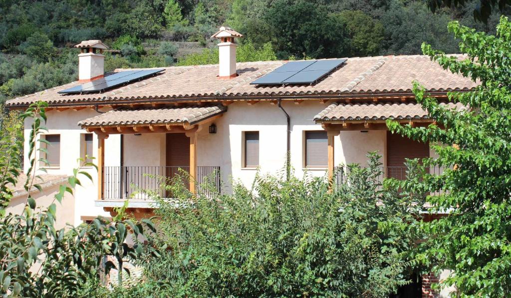 una casa con pannelli solari sopra di essa di Molino de La Médica Casa Rural de Lujo en Gredos a Candeleda