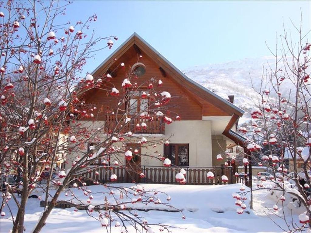 瓦盧瓦爾的住宿－Studio avec jardin clos et wifi a Valloire a 3 km des pistes，雪中的房子,前面有树木