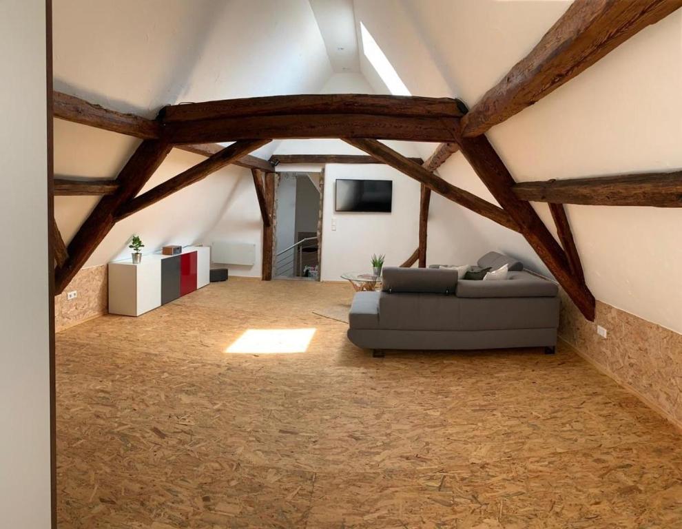 a living room with a couch in a attic at Alte Scheune Birkweiler in Birkweiler