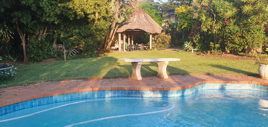 a picnic table sitting next to a swimming pool at 23 Ambleside Holiday Retreat by the sea in Port Shepstone