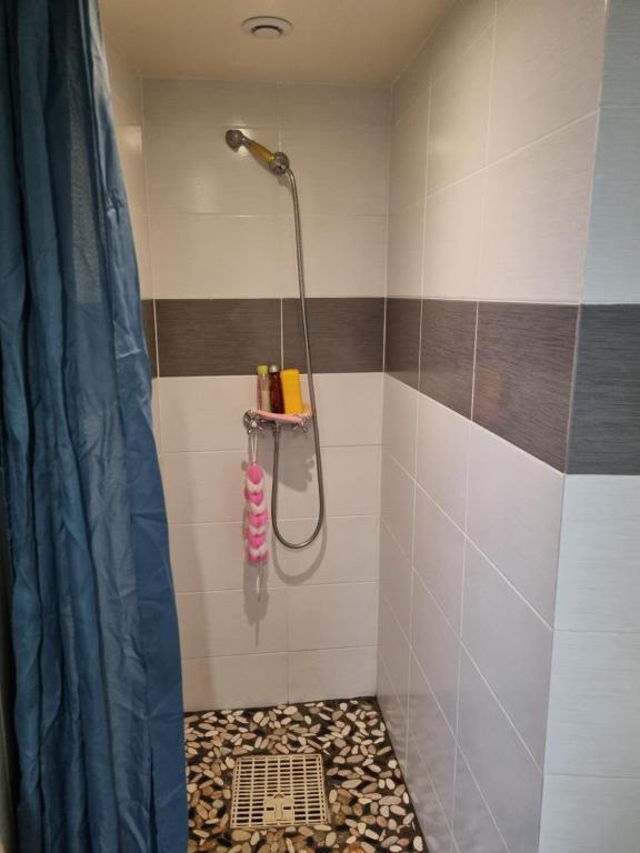 a bathroom with a shower with a tile floor at T1 meublé in Saint-Chamond