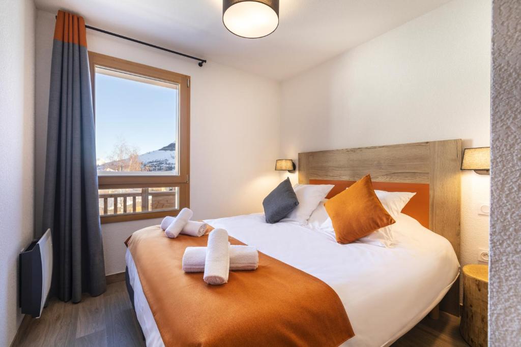a bedroom with a bed with towels on it at Résidence Club MMV Les Clarines in Les Deux Alpes