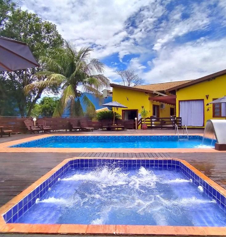 a swimming pool in front of a house at Pousada Céu de Estrelas in Bonito