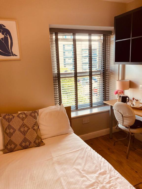 蘭卡斯特的住宿－'Bloomfield' at stayBOOM，一间卧室配有一张床、一张书桌和一个窗户。