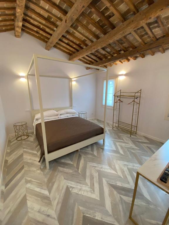 a bedroom with a bed and a wooden floor at B&B InCalle in Chioggia