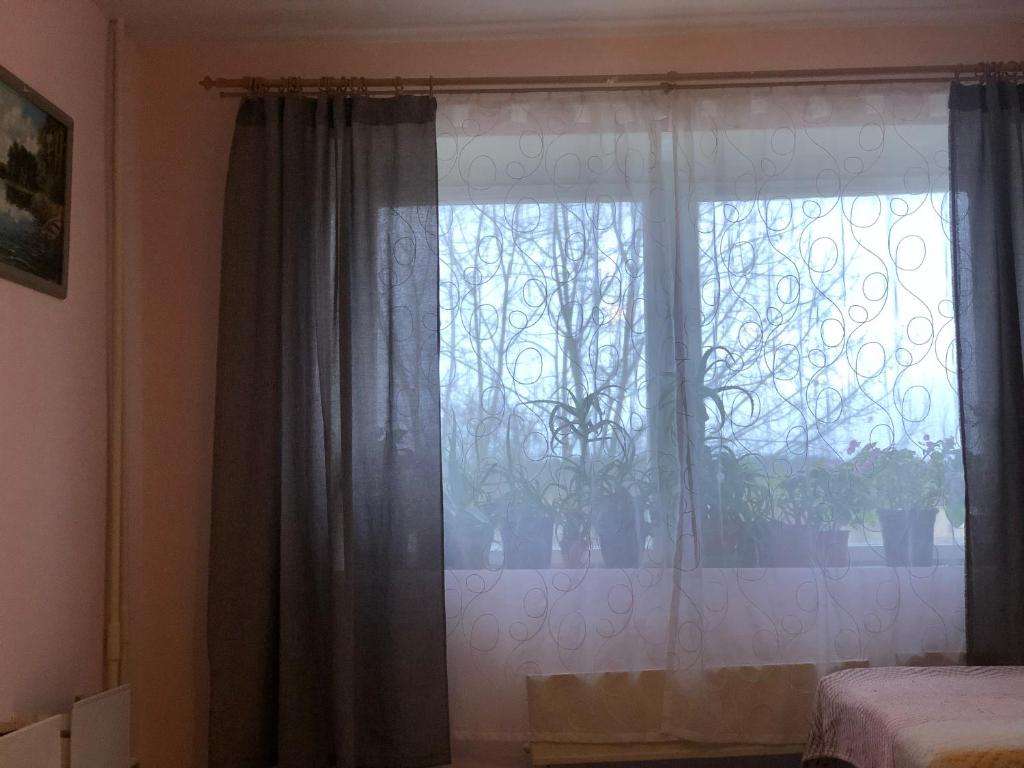 a bedroom with a window with curtains and a bed at kvartira in Krāslava