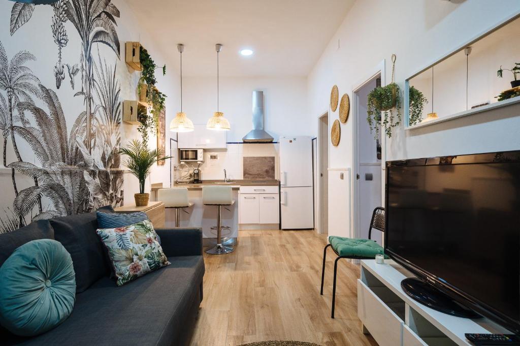 ein Wohnzimmer mit einem Sofa und einer Küche in der Unterkunft Divi Apartments Martínez Montañes in Sevilla