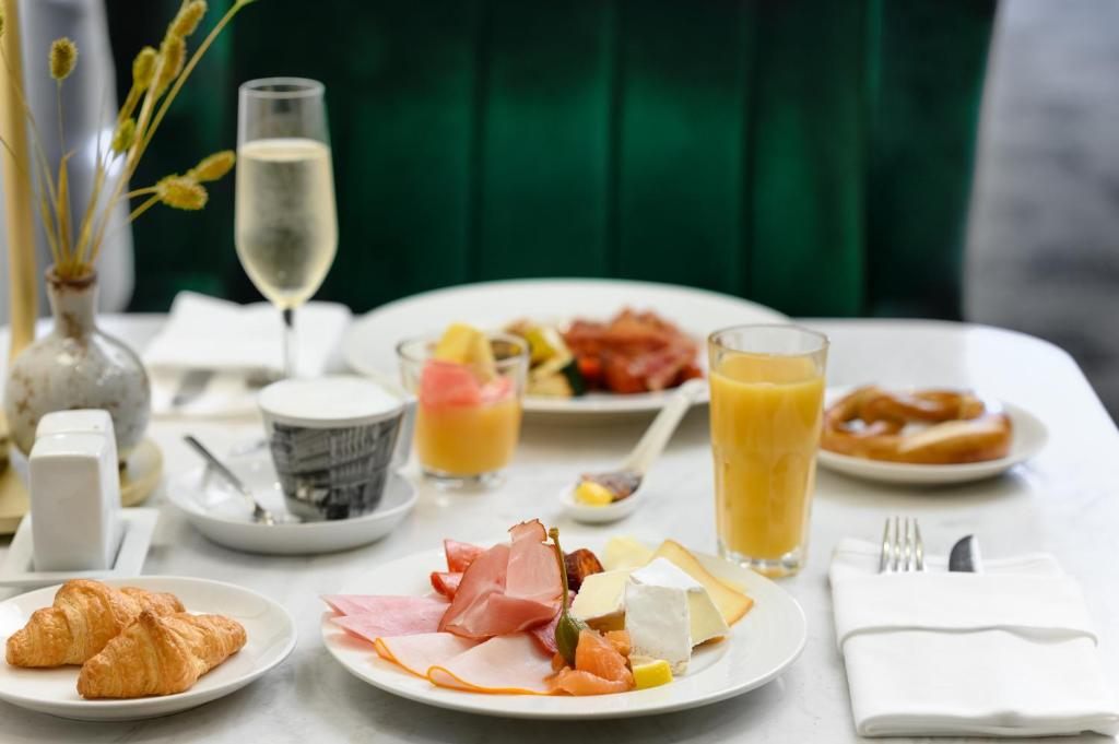 a white table topped with plates of food and drinks at Nemzeti Hotel Budapest - MGallery Collection in Budapest