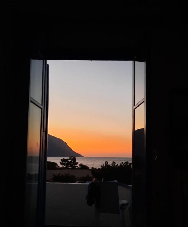 a view of a sunset through a window at Paradise in Agia Roumeli