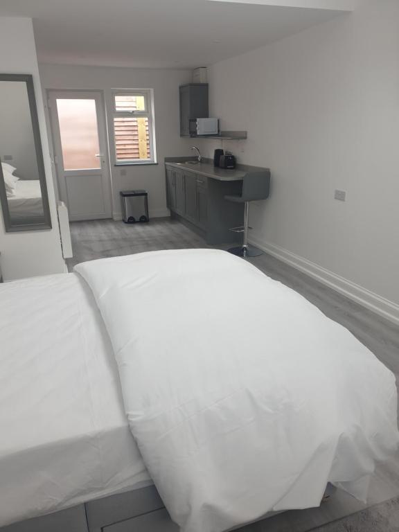 een slaapkamer met een wit bed en een wastafel bij The Bay Studio 1 in Broadstairs