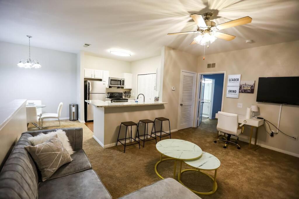 a living room with a couch and a table and a kitchen at Lux 2BD 2BA minutes from the water in Pensacola