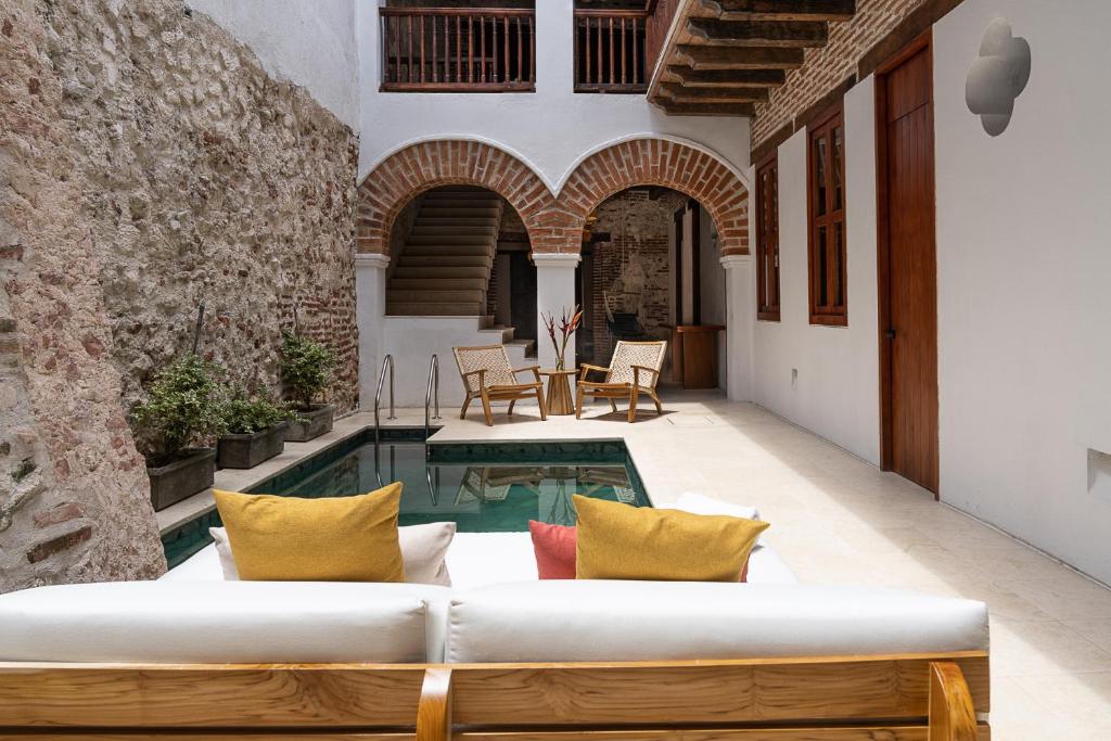 eine Außenterrasse mit einem Sofa und einem Pool in der Unterkunft Voila Getsemani in Cartagena de Indias
