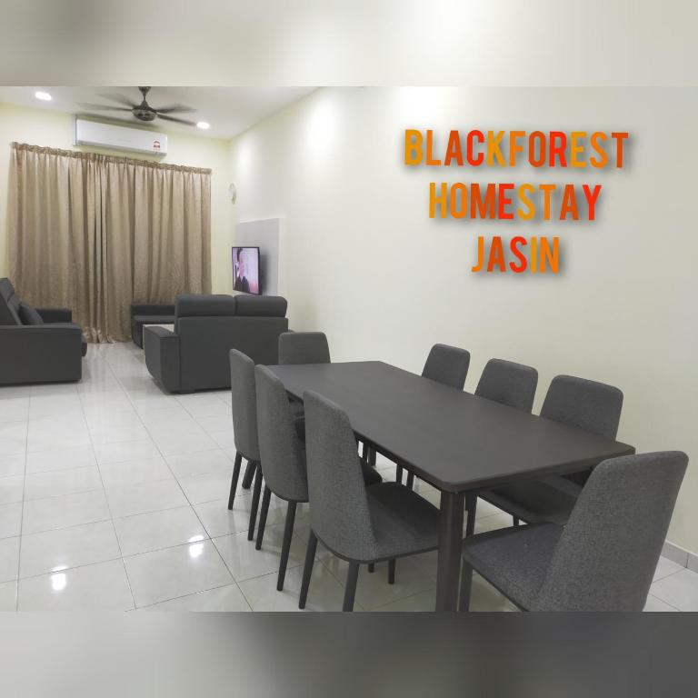 ein Esszimmer mit einem Tisch und Stühlen in einem Zimmer in der Unterkunft HOMESTAY JASIN BLACKFOREST in Jasin