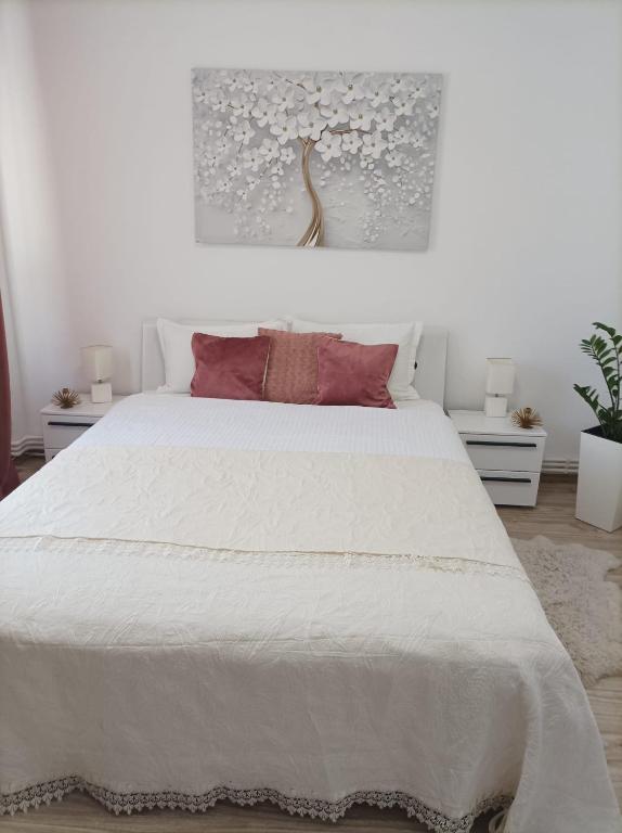 sypialnia z dużym białym łóżkiem z czerwonymi poduszkami w obiekcie Soft Apartments w mieście Gałacz