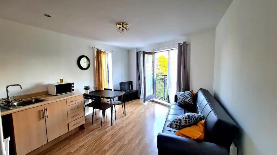a living room with a couch and a kitchen with a table at Lovely 5 Sleeper Flat - Upper Clapton in London