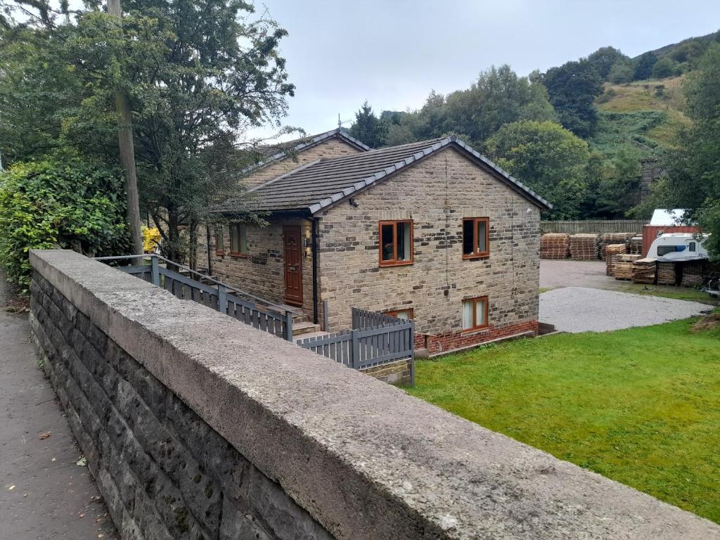 a small brick house with a stone wall at Canal View in Todmorden