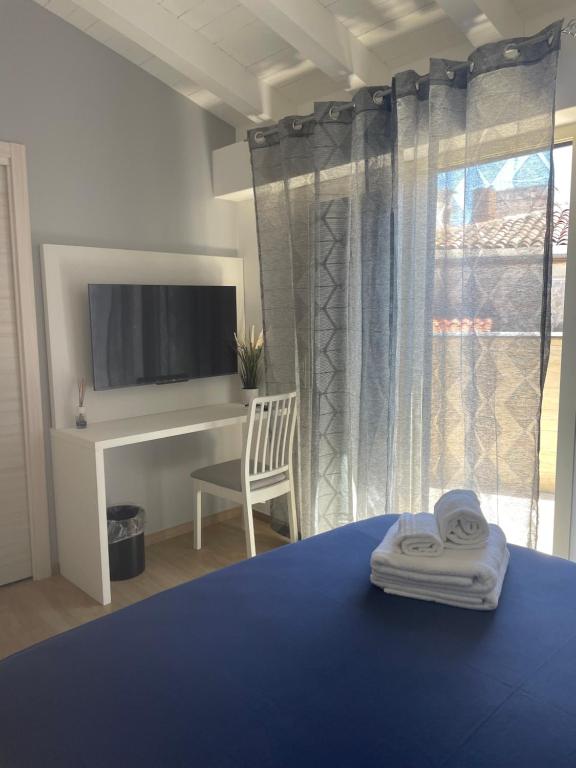 a bedroom with a bed and a tv and a window at Casa vacanze Elegance in Catania