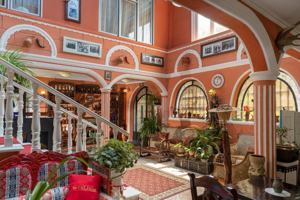 um edifício com paredes cor de laranja e uma escadaria com plantas em Elia Boutique Hostel & Apart-Hotel em Tbilisi
