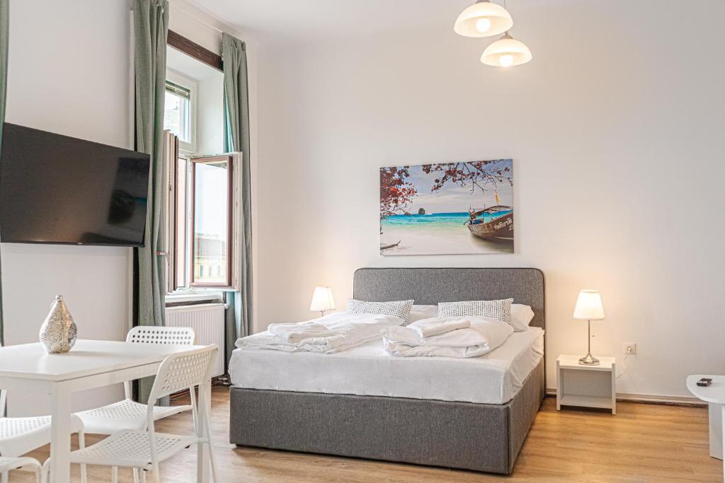 a bedroom with a bed and a table and chairs at Welcoming 2BR Apt. near AKH- Perfect for Longstays in Vienna