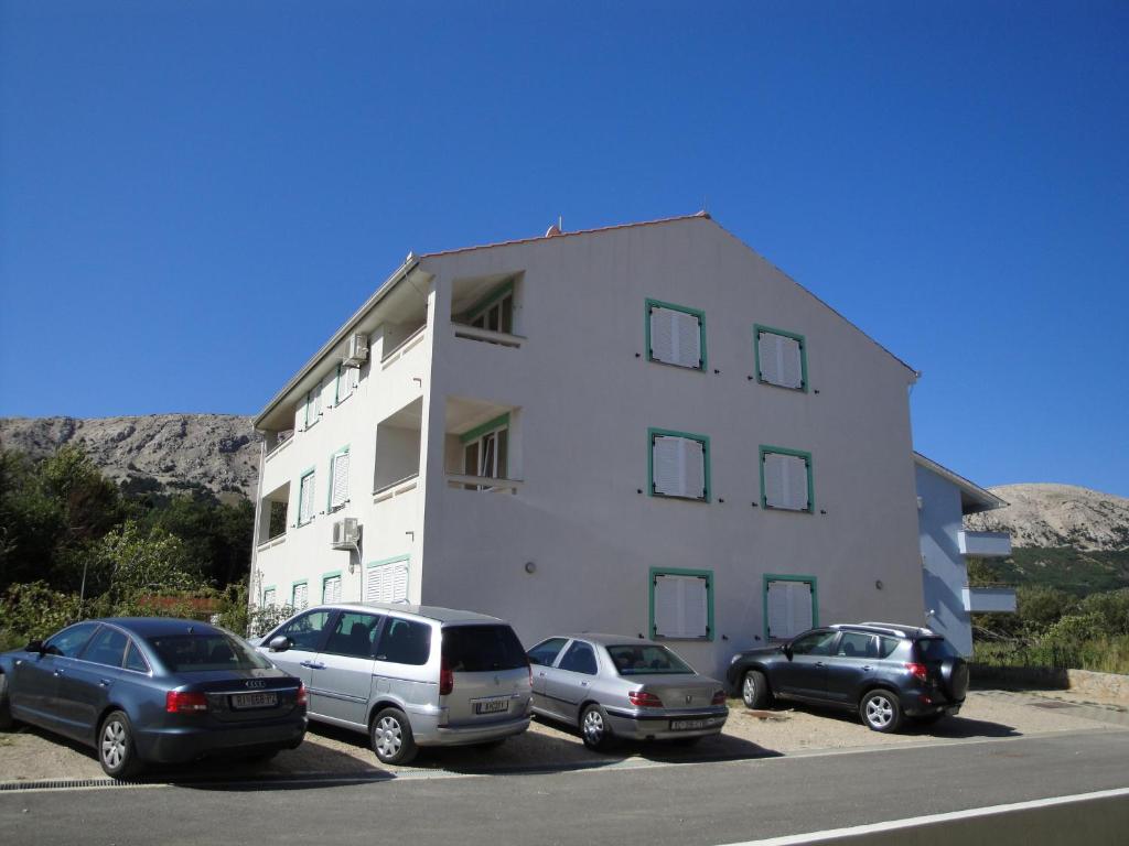 a group of cars parked in front of a building at Apartments Knezevic-Pavlic in Baška