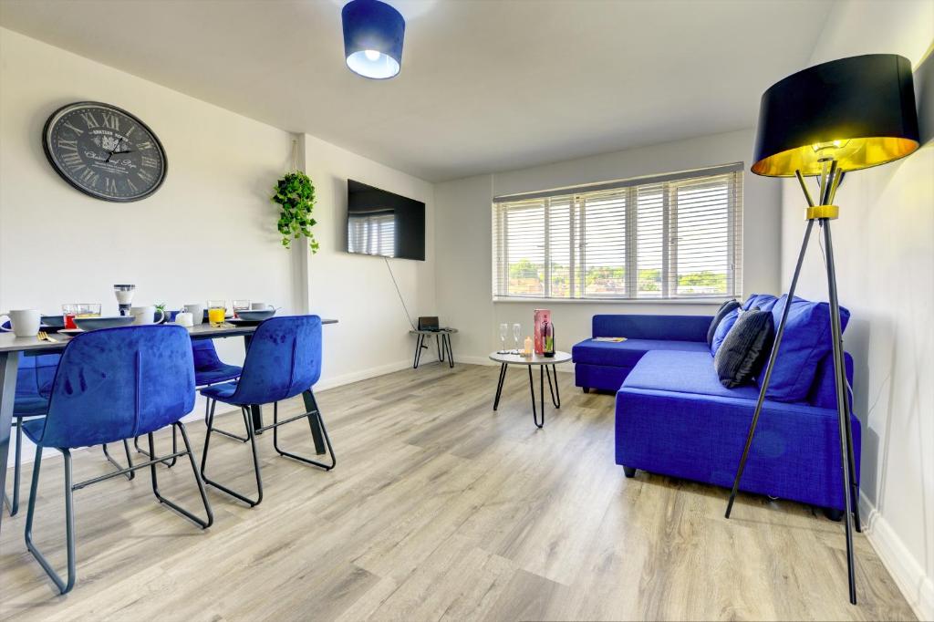 a living room with a blue couch and a table at Spacious - PENTHOUSE 2 Bed Apartment with secure allocated parking in Sheffield