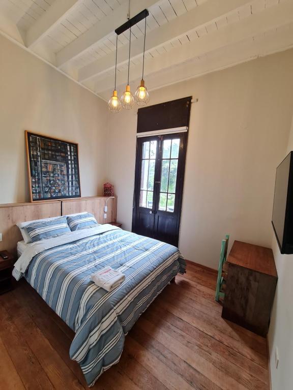 1 dormitorio con 1 cama con edredón azul y ventana en Flying Dog Lima B&B, en Lima