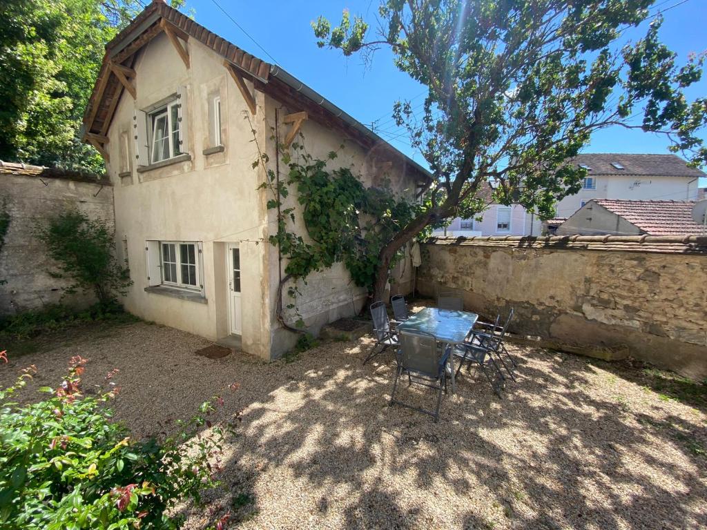 une maison avec une table et des chaises devant elle dans l'établissement Maison Individuelle avec jardin privatif, à Avon