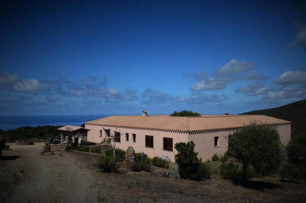 a white building with a roof in the desert at B&B Costa Verde in Arbus