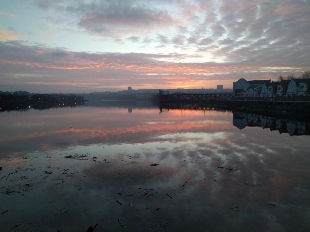 a sunset over a body of water with a pier at Riverside home. 3 bedroom. Free parking. 10 mins to Newcastle City Centre in Dunston