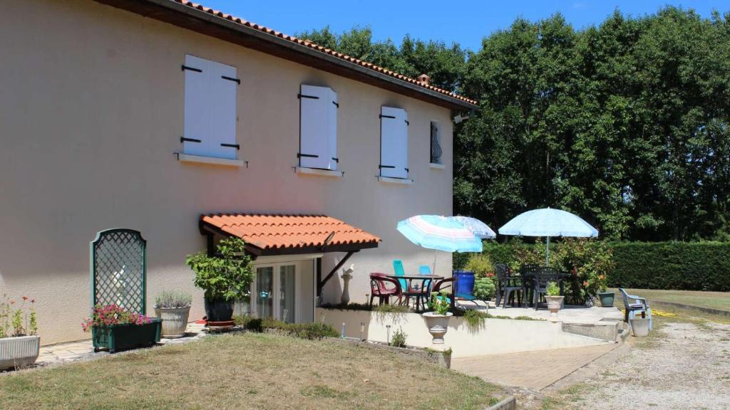 ein Haus mit 2 Sonnenschirmen und einer Terrasse in der Unterkunft LA SALAMANDRE in Chazelles