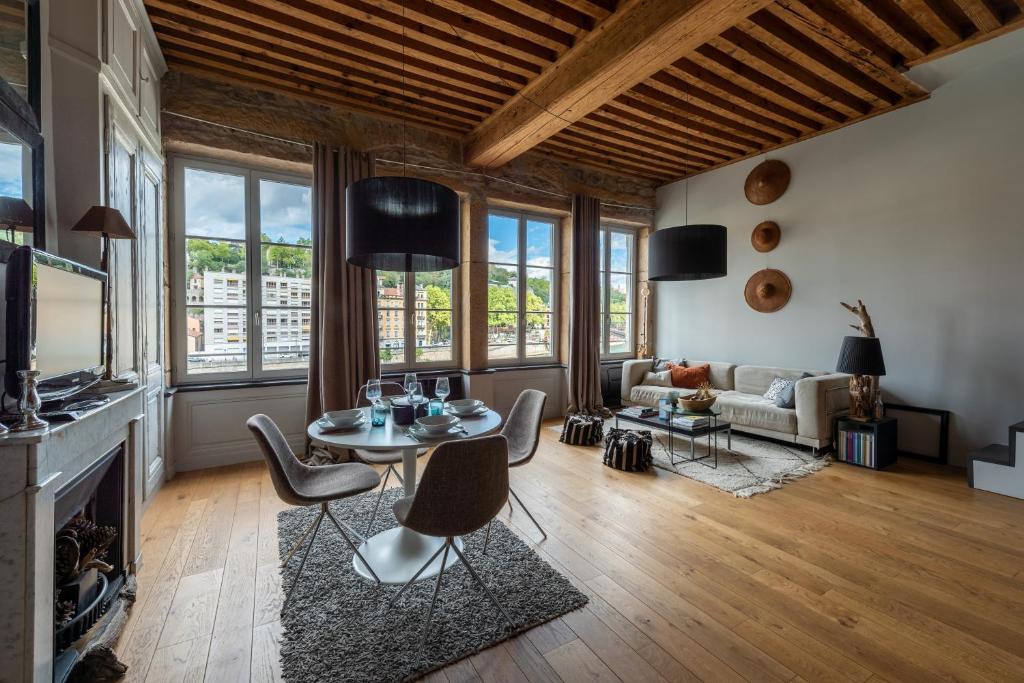 un salon avec une table, des chaises et un canapé dans l'établissement LE LOFT ETHNIC - avec jolie vue sur la Saône, à Lyon