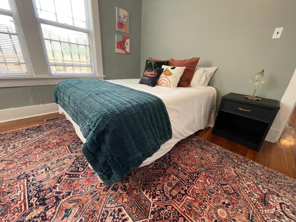 a bedroom with a bed with a green blanket and a rug at Historic Revival 2BR Midtown Memphis Fast Wifi Free Parking Yes Pets in Memphis