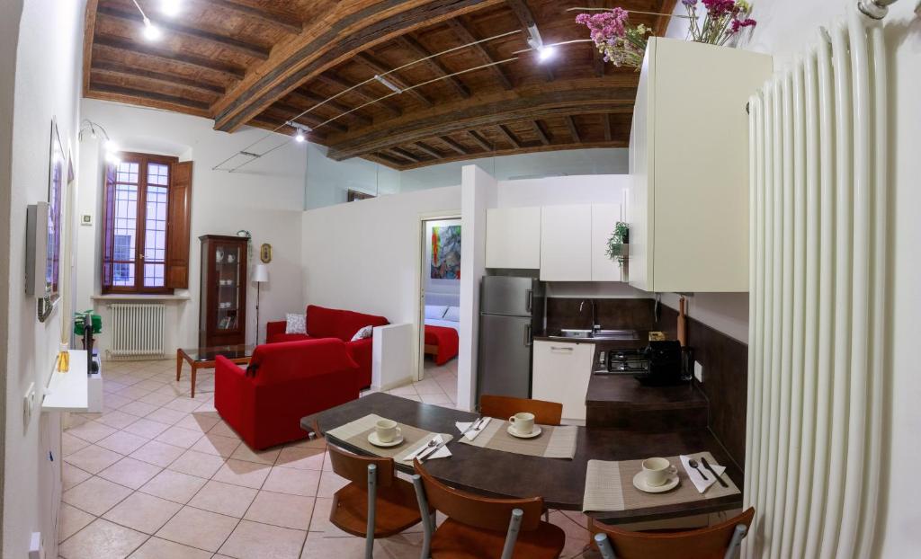 un soggiorno con tavolo e divano rosso di Appartamento Andrea Amati nel Cuore di Cremona a Cremona