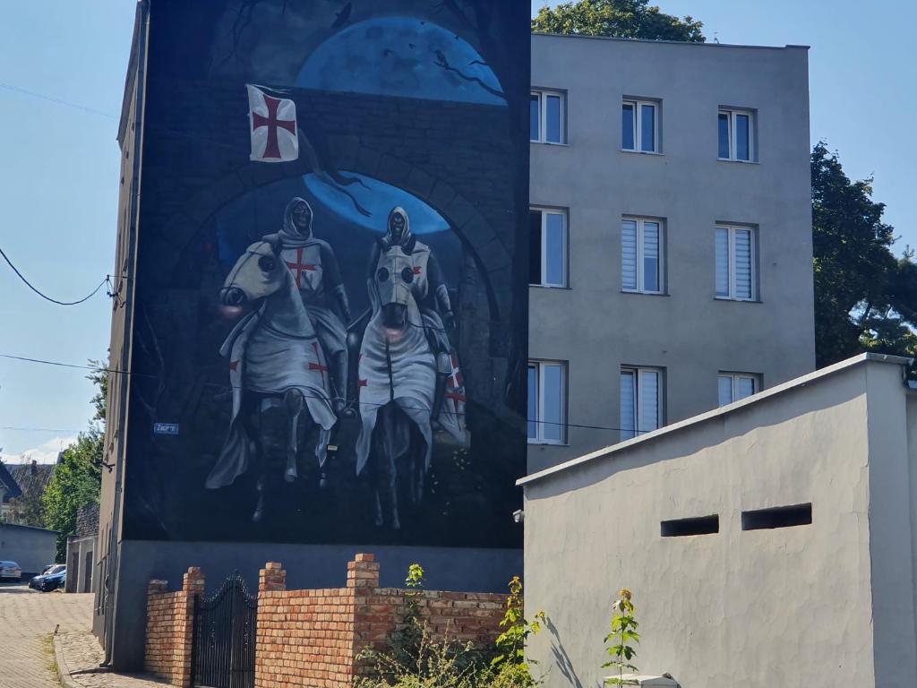 une grande fresque murale sur le côté d'un bâtiment dans l'établissement Hostel Zacisze 2, à Głubczyce