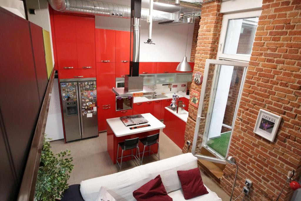 cocina con armarios rojos y encimera blanca en Duplex en Chamberi Osoteca en Madrid