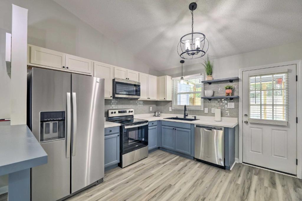 a kitchen with stainless steel appliances and blue cabinets at Jacksonville Retreat with Yard about 16 Mi to Beach in Jacksonville