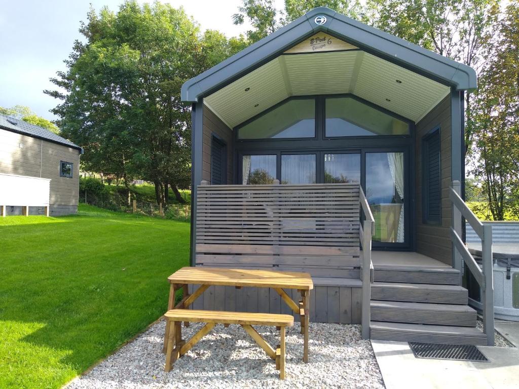 a tiny house with a bench in front of it at The Cuddies in Balloch
