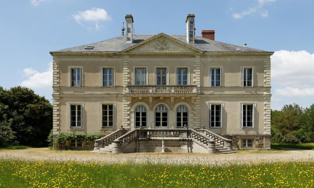 ein altes Haus mit einer Treppe davor in der Unterkunft Chateau du Hallay in Montaigu-Vendée