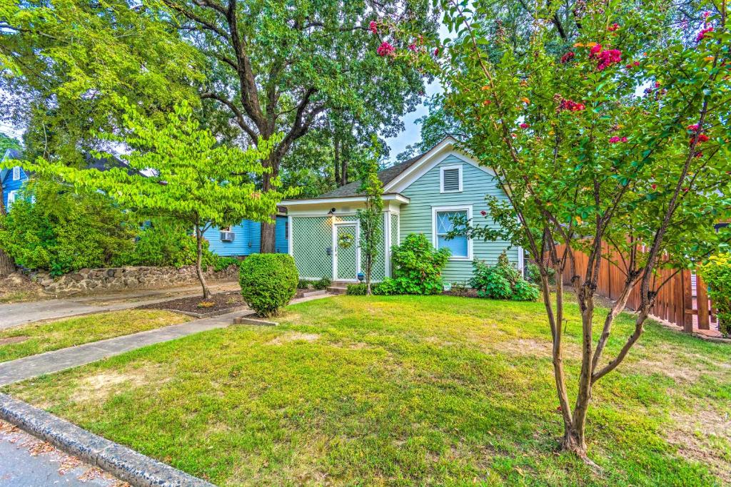 une maison bleue avec un arbre dans la cour dans l'établissement Colorful Cottage with Deck about 5 Mi to Downtown!, à Little Rock