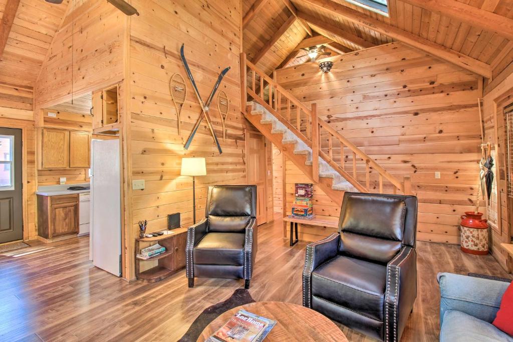 een woonkamer met 2 stoelen en een wenteltrap bij Relax and Play in the Pines Cabin with Deck! in Pinetop-Lakeside