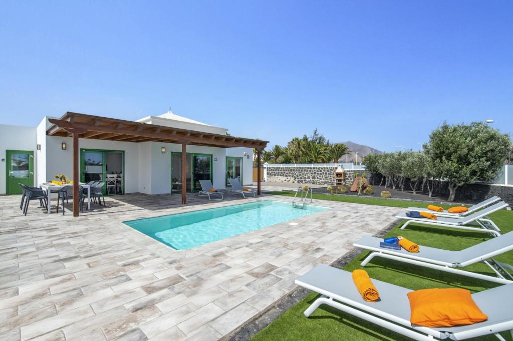 a villa with a swimming pool and a patio at Villa Arena by Villa Plus in Playa Blanca