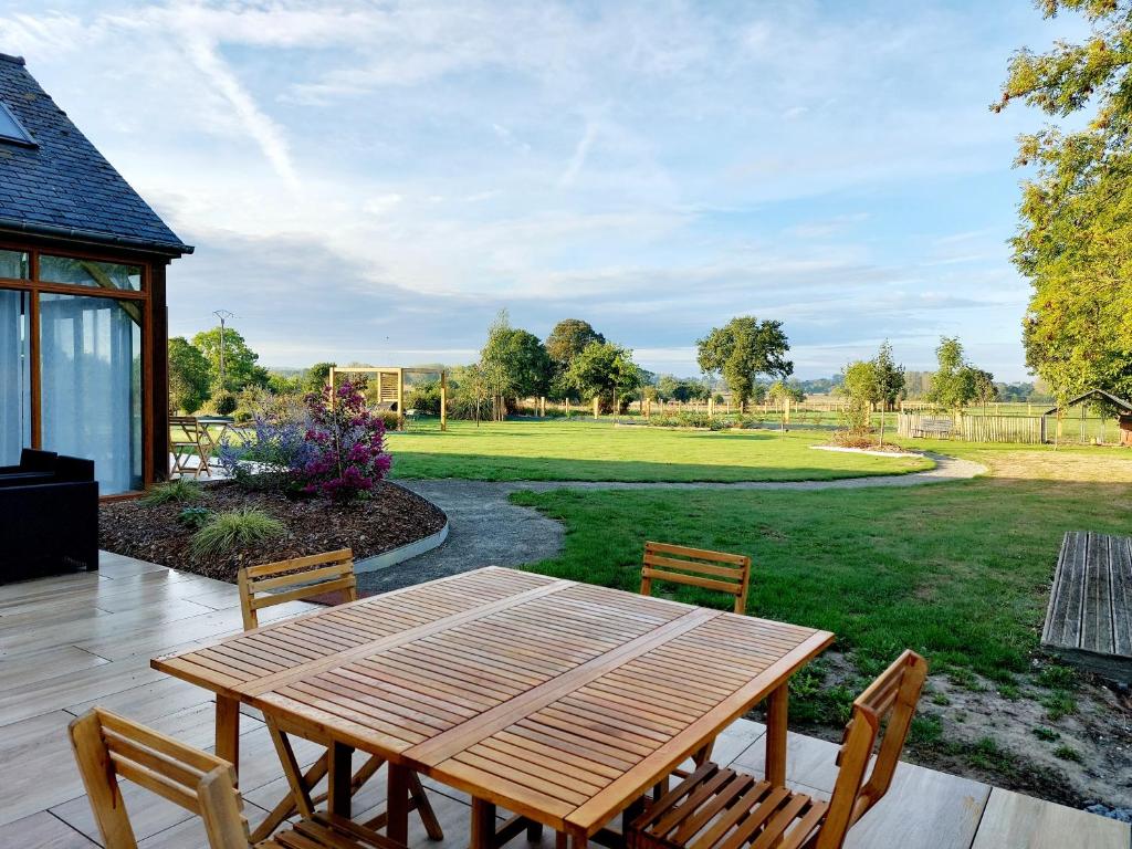 a wooden table and chairs on a patio at Chambres d&#39;hôtes chez l&#39;habitant - Bed&amp; Breakfast homestay in Huisnes-sur-Mer