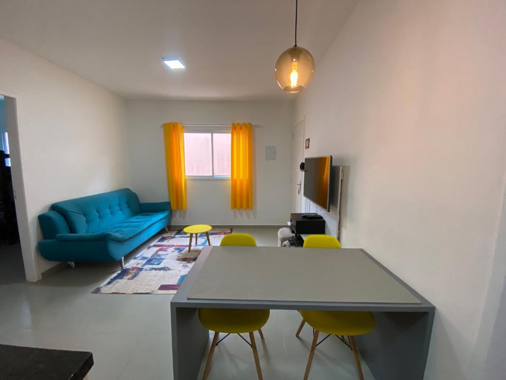 uma sala de estar com um sofá azul e cadeiras amarelas em Casa em Bertioga condomínio 250 metros da praia em Bertioga